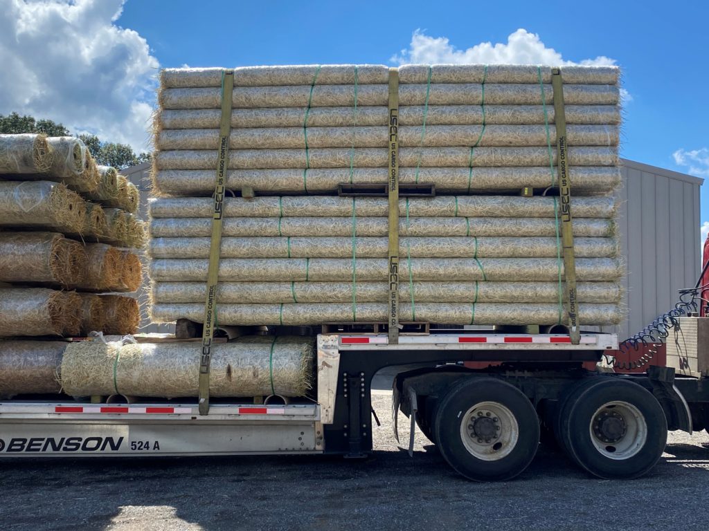 Drop deck trailer loaded with straw mats